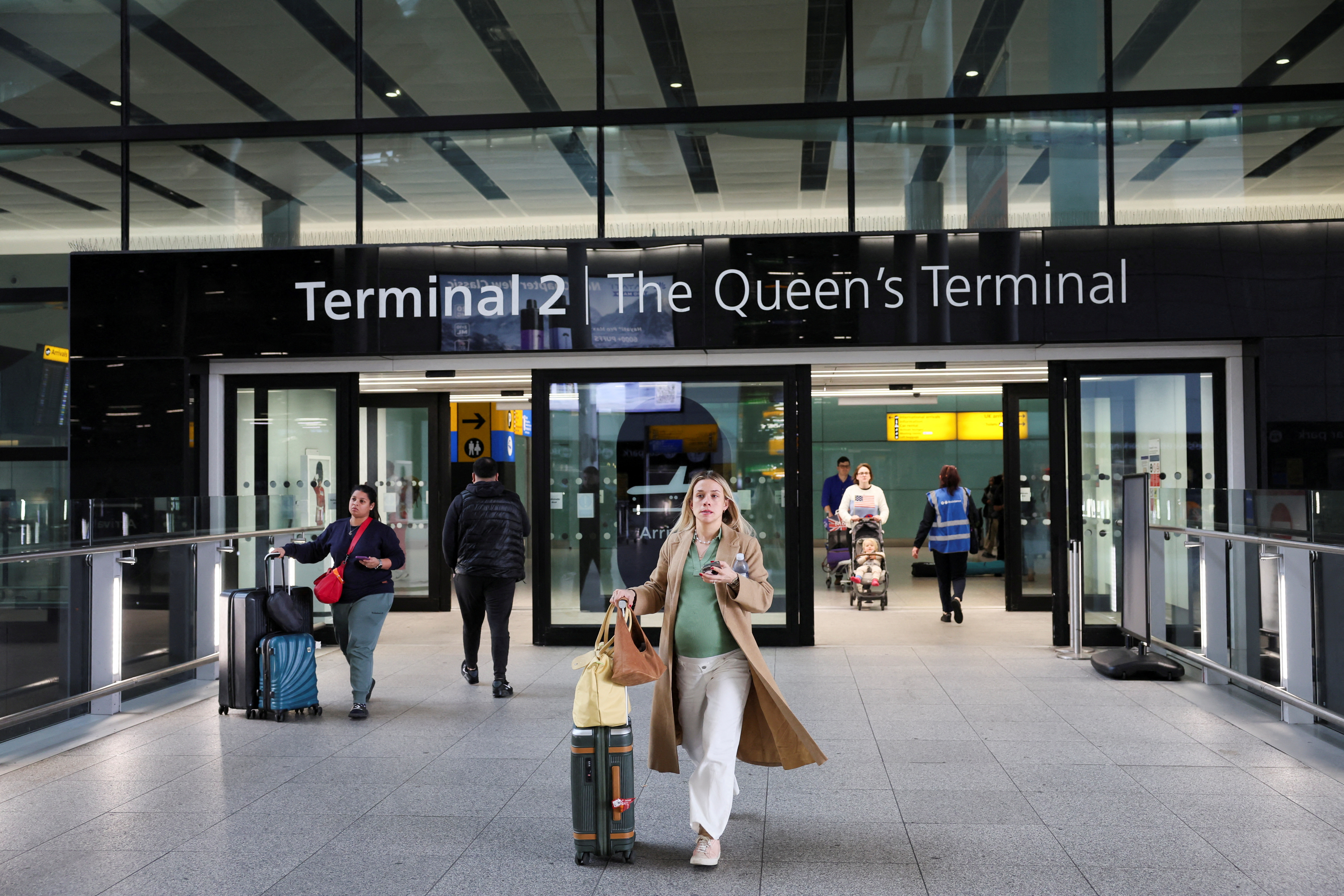 People walk at Terminal 2 of the Heathrow International Airport, near London, Britain. (REUTERS)